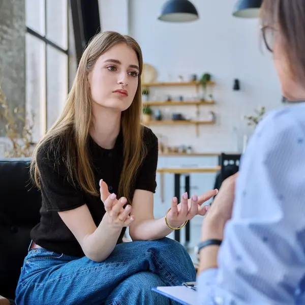 Eine Jugendliche sitzt in einer Beratung
