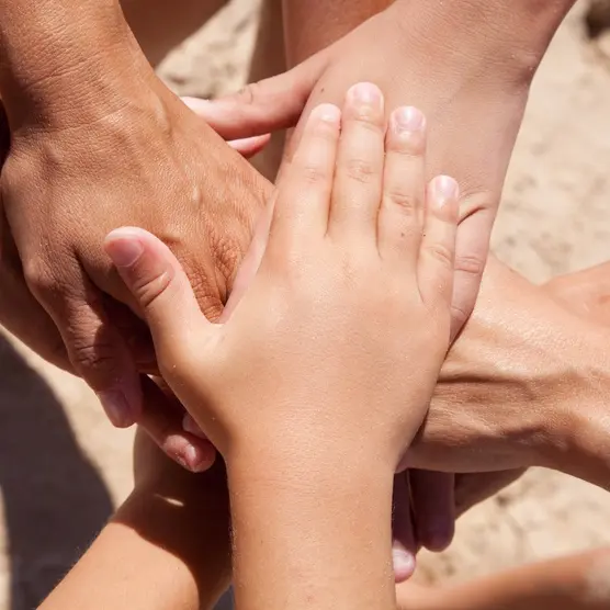 Hände von Kindern, Jugendlichen und Erwachsenen übereinander gelegt